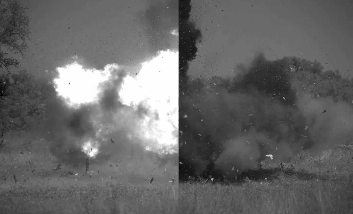 Split-screen high-speed frame from a 600 gram C-4 test. The unmitigated left side shows a large bright fireball and smoke; the mitigated right side shows dark smoke and debris with no large fireball.