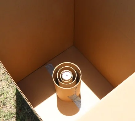 Looking down into a box with concentric empty kraft cylinders around a charge.