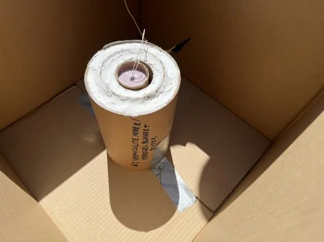 Looking down into a box with concentric kraft cylinders filled with media and sealed with a thin plaster layer.
